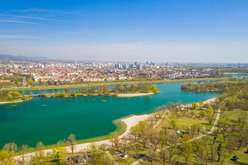Obraz premium Zagreb, Croatia, Jarun lake, beautiful green recreation park area, sunny spring day, panoramic view from drone, city in background