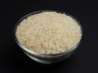 White basmati rice in a glass bowl on a black background