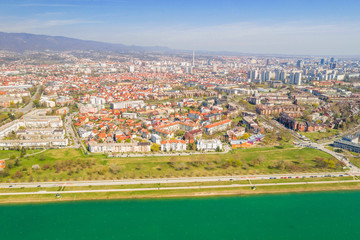 Zagreb, Croatia, Jarun lake, beautiful green recreation park area, sunny spring day, panoramic view from drone, city in background