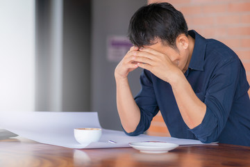 Close up of casual serious man sitting head in hands at the office