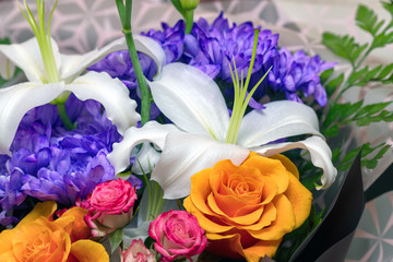 Lily in a bouquet with blue, red and orange flowers