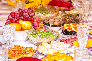 Fototapeta na wymiar Snacks, fruits, sandwiches, salads, caviar and slicing on the holiday table