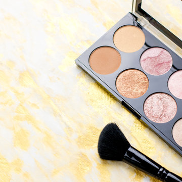 Highlighter palette closeup, make up cosmetics in black and gold. Fashion flat lay, top view