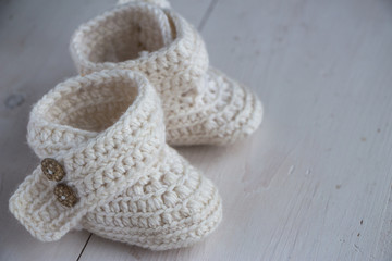 Newborn baby booties, beige, cozy and nice. Child clothe and boots - knitted and sweet. Text space, copy past and place for your design