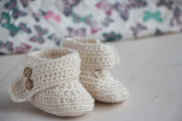 Fototapeta na wymiar Newborn baby booties, beige, cozy and nice. Child clothe and boots - knitted and sweet. Text space, copy past and place for your design