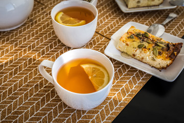 Breakfast tea with lemon in white cup and cottage cheese casserole