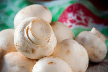 Fresh, raw champignons lie on the fabric, ready for cooking. Top right copy space.