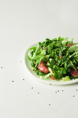 Healthy green vegan salad with grapfruit in white plate