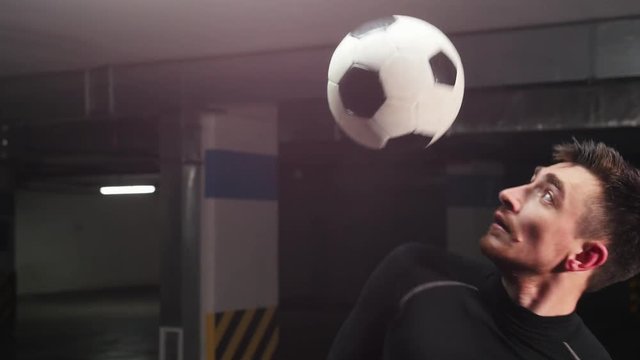 A young soccer man training his football tricks. Hitting the ball with his shoulder