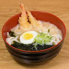 tempura udon with fried shrimps, boiled egg, green algae, leeks, tipical japanese noodles