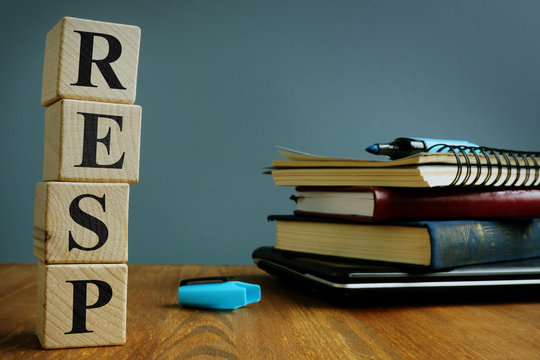 Registered Education Savings Plan RESP. Wooden Cubes And Notebooks.