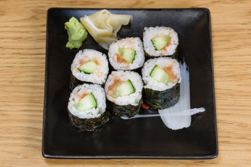 sushi roll of cucumbers and umekyu served on a black plate
