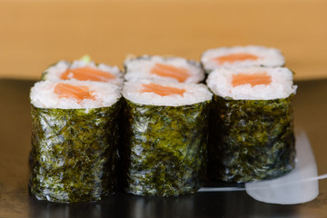 typical salmon sushi roll, served with gari and wasabi
