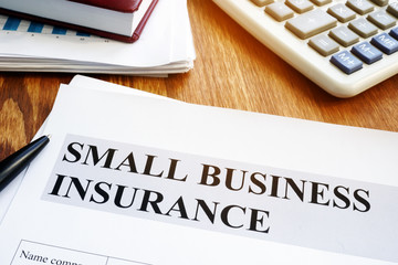 Small business insurance policy on a wooden desk.