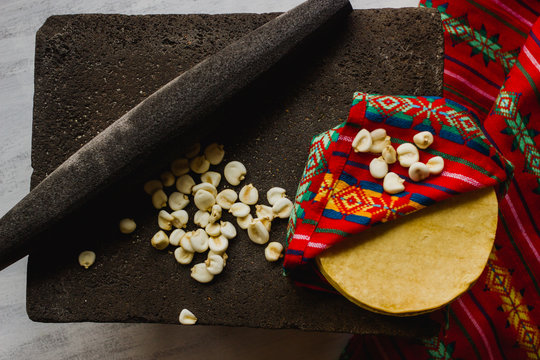 Mexican tortillas and corn on a metate. Mexico traditional culture, pre-hispanic food