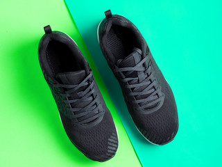 Sporting a pair of sneakers on a coloured background