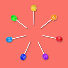 Set of colorful lollipops grouped in a circle isolated on coral background.