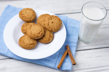 Glass of milk and cookies on a wooden white table