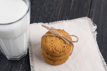 Oatmeal cookies with milk on wooden background