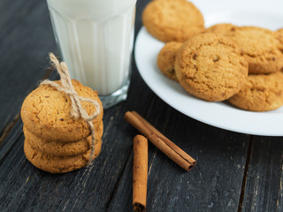 Oatmeal cookies with milk on wooden background