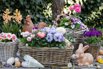 Osterdekoration mit Osterhasen und Frühlingsblumen in Töpfen