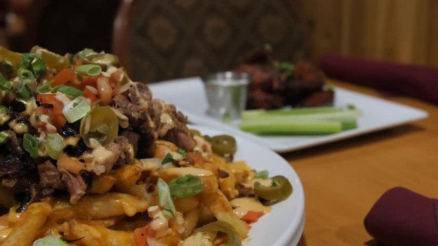 hillbilly french fries jalepenos brisket fry sauce pan from left to right. Left to right panning shot of a hillbilly french fries with jalapenos, brisket, fry sauce in a white plate. Close-up setting.