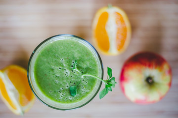 Good morning: Fresh green smoothie and fruits on wooden background, healthy breakfast