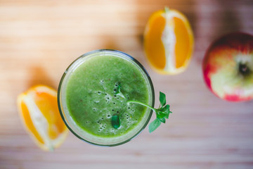 Good morning: Fresh green smoothie and fruits on wooden background, healthy breakfast