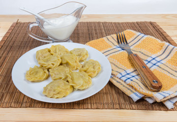 Cooked homemade meat dumplings and sauce on bamboo table mat