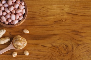 Peanut in wooden bowl on classic wooden table background, peanut butter