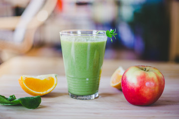 Fototapeta premium Good morning: Fresh green smoothie and fruits on wooden background, healthy breakfast