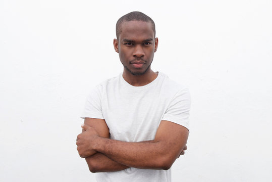 handsome young black man posing with arms crossed against white background