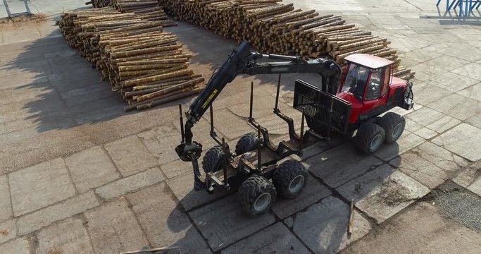 A truck rides through the factory, a logger for transporting logs rides between the rows of logs