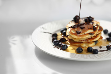 Sweet breakfast. Pancakes with blueberries and maple syrup. 
