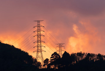 High voltage electric pole and transmission lines in the evening. Electricity pylons at sunset. Power and energy. Energy conservation. High voltage grid tower with wire cable at distribution station.