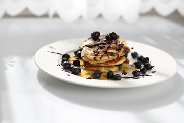 Sweet breakfast. Pancakes with blueberries and maple syrup. 