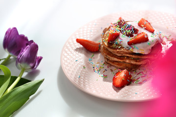  Sweet pancakes with strawberries, cottage cheese and colorful sugar sprinkles.