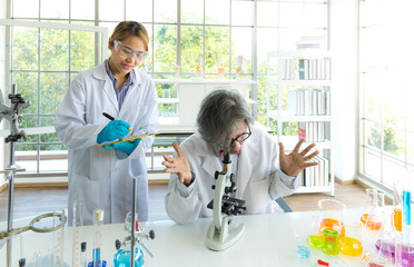 Obraz premium Young female research scientist and Senior male professor researchers working in life scientific laboratory.