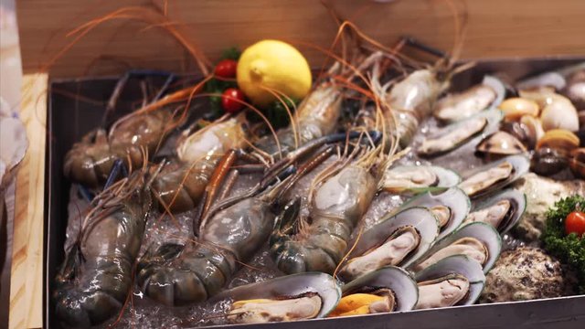 Close view of big prawns and mussels on ice in Bangkok food court, Thailand