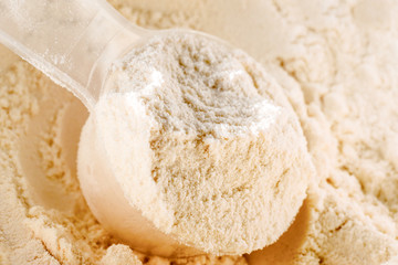 Whey protein scoop. Plastic spoon with sports nutrition.