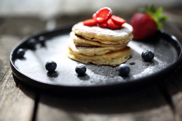  Pancakes with strawberries, blueberries and powdered sugar. 
