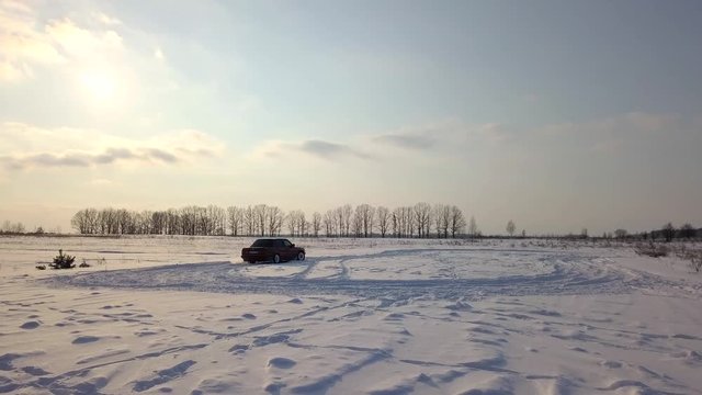 Red retro car drift on a field in the snow