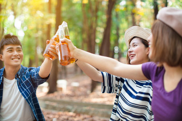 Naklejka premium young Friends hands toasting beer and having fun cheering
