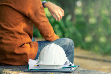 The while wearing protective equipment safety helmet at construction site and Engineer or Architect...