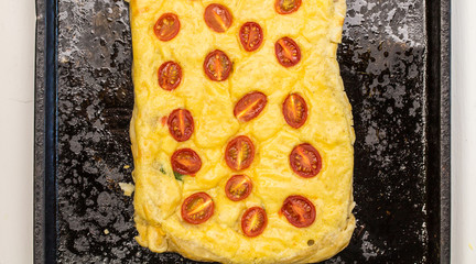 Cherry tomato, egg and cheese tart baked on rustic pan