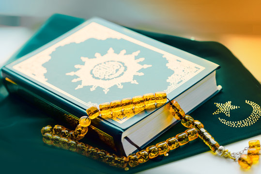 Holy islamic book Koran on the draped table with a rosary. Ramadan Kareem beautiful poster, banner, postcard for the celebration of the festival of the Muslim community