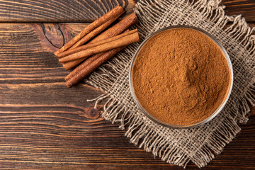 Cinnamon on dark wooden background. 