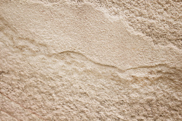 Old brown sandstone background in seamless wave shaped patterns nature texture
