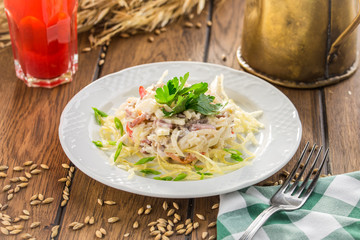 The fresh mayonaisse salad with parsley on top on wooden table