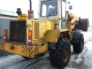 Big yellow powerful tractor cleans snow.